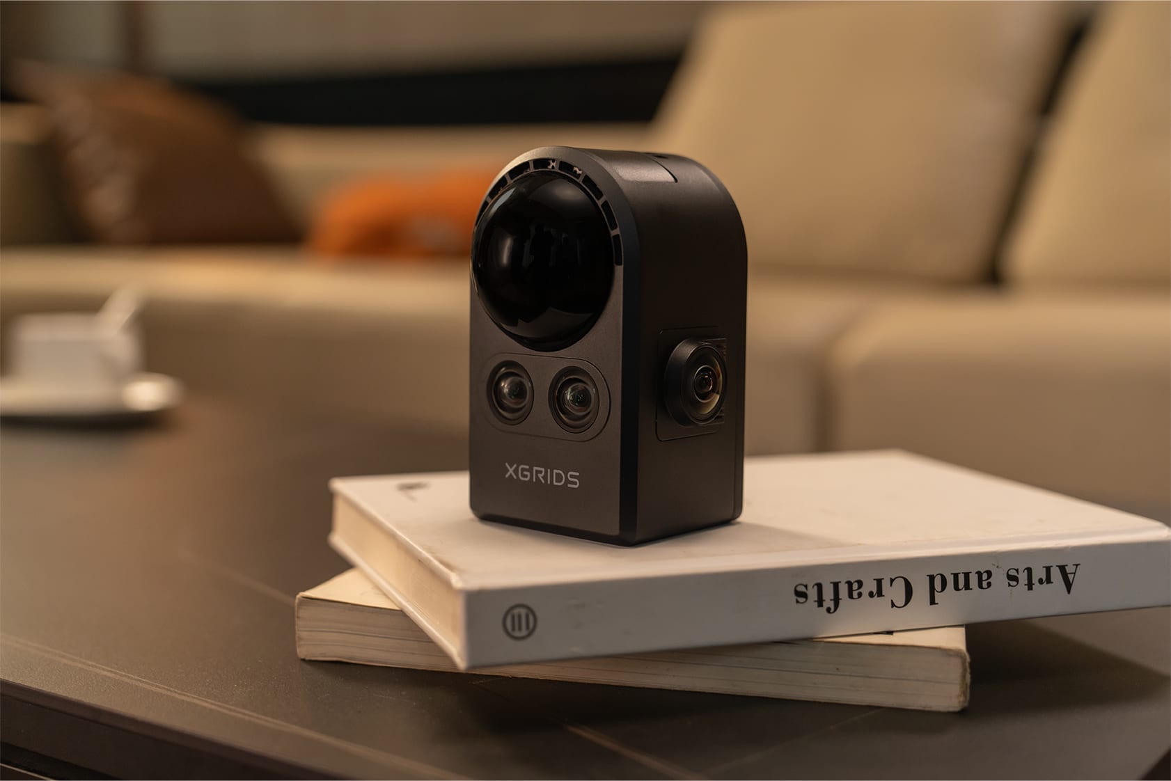 PortalCam handheld scanner near books on a coffee table, moody lighting