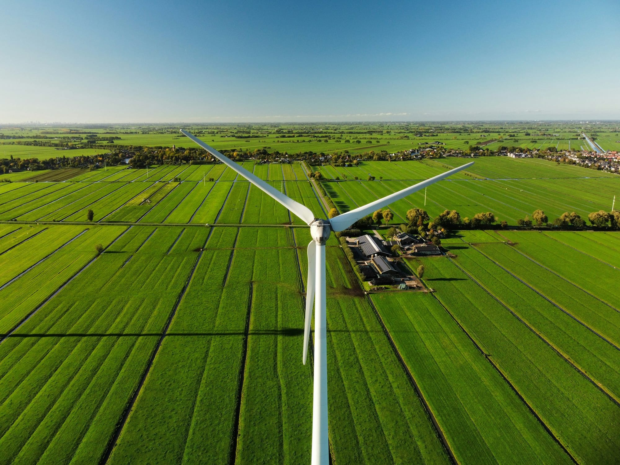 Aerial drone shot of a wind turbine over farmland